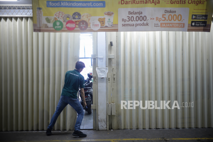 Pegawai minimarket menutup pintu toko saat pemberlakuan jam malam di kawasan Margonda, Depok, Jawa Barat, Senin (31/8). Pemerintah Kota Depok memberlakukan jam malam bagi warga hingga pukul 20.00 WIB dan  pembatasan jam operasional layanan secara langsung bagi kafe, minimarket, rumah makan dan mal hingga pukul 18.00 WIB dan layanan antar hingga pukul 21.00 WIB  yang diterapkan mulai hari ini mengingat kasus COVID-19 di Depok merupakan yang tertinggi di Jawa Barat dengan kasus terakhir sebanyak 2.152 kasus positif.