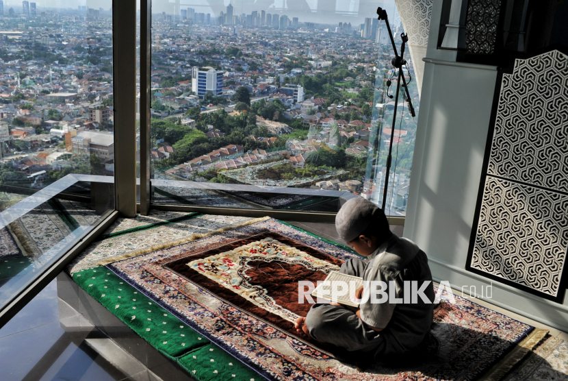 Anak membaca Al Quran di Masjid Ar-Rahim Menara 165, Jakarta, Rabu (12/3/2025). Masjid Ar-Rahim merupakan salah satu masjid tertinggi di Jakarta yang dibangun di atas Menara 165 lantai 27 dengan kontur bangunan segitiga dan bertuliskan Allah dalam bahasa arab.  Masjid yang berada di gedung perkantoran tersebut memberikan daya tarik tersendiri yang menyajikan sensasi beribadah di atas ketinggian dengan pemandangan lanskap perkotaan yang dapat diakses oleh masyarakat umum.