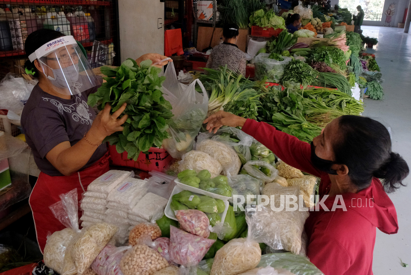 Pedagang menggunakan alat pelindung wajah saat melayani pembeli di pasar tradisional (ilustrasi). Badan Ketahanan Pangan (BKP) menyiapkan sistem panel harga komoditas pangan tingkat petani untuk meningkatkan kontrol harga produsen.