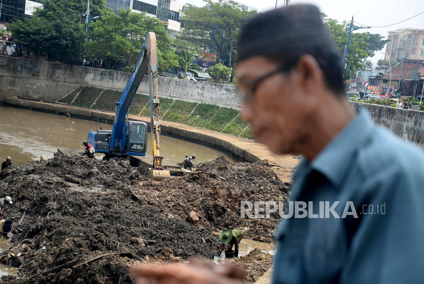 Pekerja dengan alat berat mengeruk endapan sampah bercampur lumpur di Sungai Ciliwung kawasan Jatinegara Barat, Jakarta, Kamis (23/7). Pengerukan tersebut untuk menormalkan kedalaman sungai sehingga aliran air semakin lancar. 