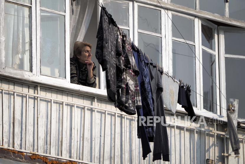  Seorang wanita melihat melalui jendela apartemennya di Stepanakert, wilayah separatis Nagorno-Karabakh, Selasa, 3 November 2020. Pertempuran memperebutkan wilayah separatis Nagorno-Karabakh memasuki minggu keenam pada hari Minggu, dengan pasukan Armenia dan Azerbaijan saling menyalahkan. lainnya untuk serangan baru.