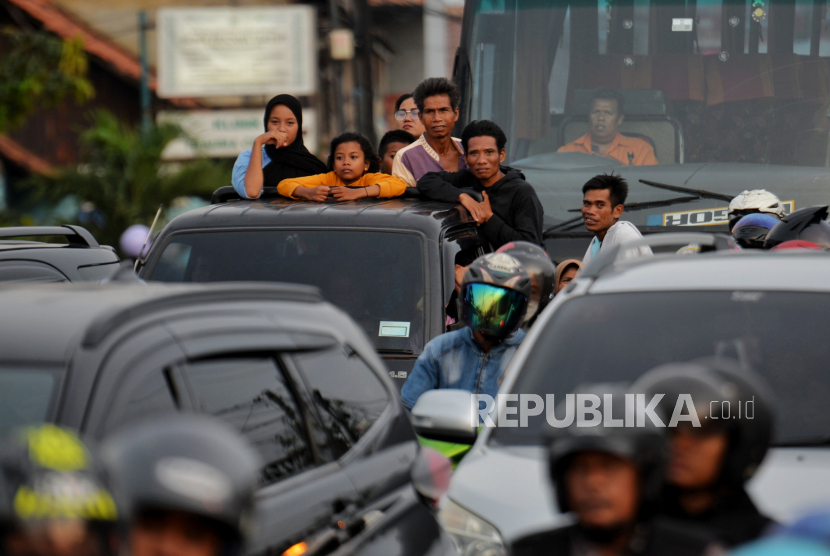 Pemudik menggunakan kendaraan bak terbuka melintas di Jalan Raya Kelari, Karawang, Jawa Barat.