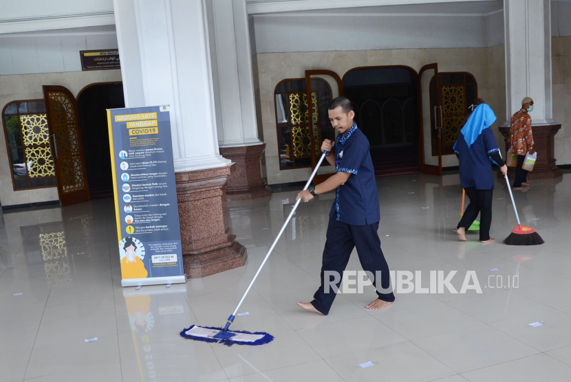 Petugas membersihkan serambi Masjid Al-Muttaqien sebelum masuk waktu Zuhur, di kompleks Gedung Sate, Kota Bandung.