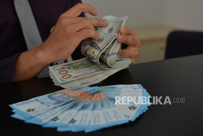 Teller menghitung mata uang Dolar AS di kantor cabang Bank Muamalat Bintaro Jaya, Tangerang Selatan.