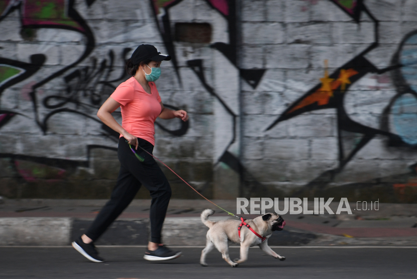 Seorang warga berolahraga dengan membawa anjing peliharaan di jalan MH Thamrin Jakarta. Dokter sarankan perhatikan kondisi tubuh agar tidak cedera saat olahraga