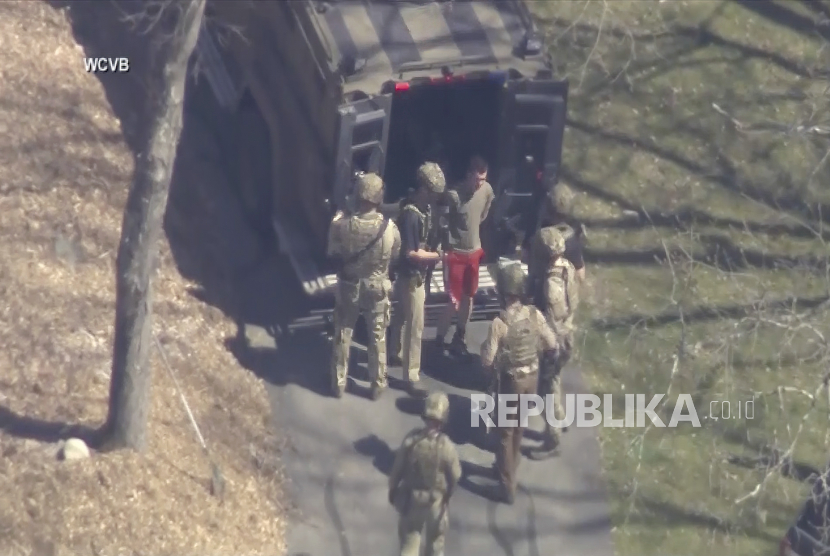 Gambar ini dibuat dari video yang disediakan oleh WCVB-TV, menunjukkan Jack Teixeira, dengan kaus dan celana pendek, ditahan oleh agen taktis bersenjata pada Kamis (13/4/2023), di Dighton, Mass.