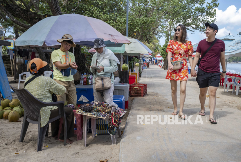  Wisman berjalan-jalan di pantai Kuta, Bali. Menteri Pariwisata dan Ekonomi Kreatif Sandiaga Salahuddin Uno, mengatakan, jumlah kunjungan wisman asal India pascapandemi terus menunjukkan tren positif.