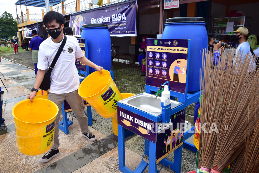 Seorang peserta merapikan peralatan sarana kebersihan pada pencanangan Gerakan BISA (Bersih, Indah, Sehat dan Aman).