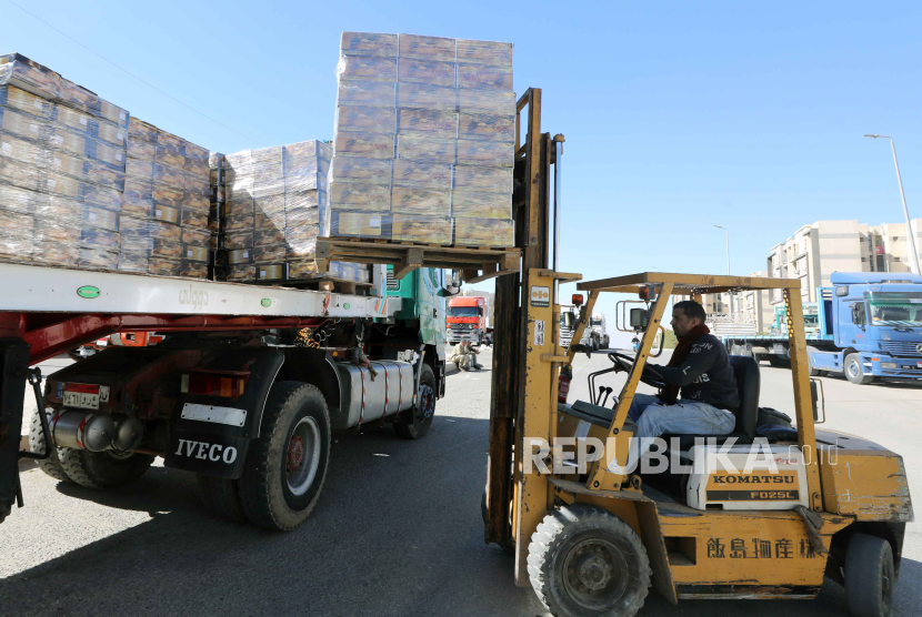 Pekerja memuat kotak berisi kurma ke dalam truk saat organisasi non-pemerintah Bank Makanan Mesir menyiapkan sumbangan makanan untuk warga Palestina di Jalur Gaza, di New Kairo, Mesir, (11/2/20240