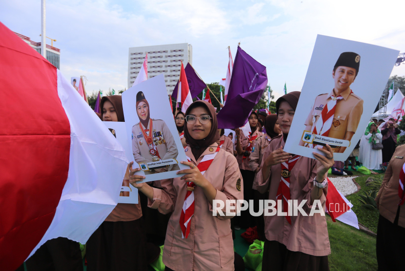 Anggota Pramuka Kwarda Jawa Timur membentangkan poster saat tasyakuran dan doa bersama penyambutan Gubernur dan Wakil Gubernur Jawa Timur di halaman Gedung Negara Grahadi, Surabaya, Jawa Timur, Ahad (2/3/2025). Pemprov Jawa Timur menggelar tasyakuran dan doa bersama menyambut Gubernur dan Wakil Gubernur Jawa Timur periode 2025-2030 Khofifah Indar Parawansa dan Emil Elestianto Dardak dengan dihadiri tokoh agama, perwakilan partai politik, masyarakat, organisasi kepemudaan dan perempuan serta anggota Pramuka Kwarda Jawa Timur. 