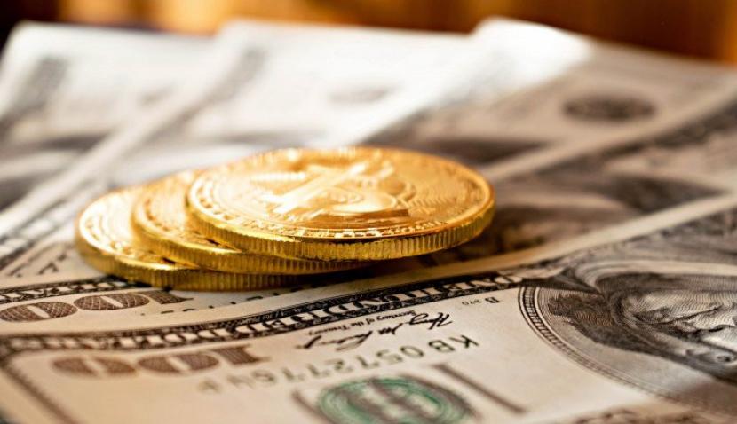 Ilustrasi bitcoin di atas mata uang dolar AS. (Unsplash/Dmitry Moraine)