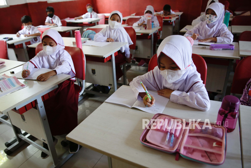 Siswa memakai masker saat belajar di kelas di sebuah sekolah dasar di Depok, Indonesia, 03 Januari 2022. 
