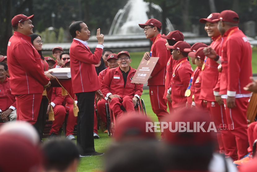Presiden Joko Widodo (kedua kiri) didampingi Menpora DIto Ariotedjo (kiri) menyerahkan bonus kepada kontingen ASEAN Para Games di halaman Istana Merdeka, Jakarta, Senin (3/7/2023). 