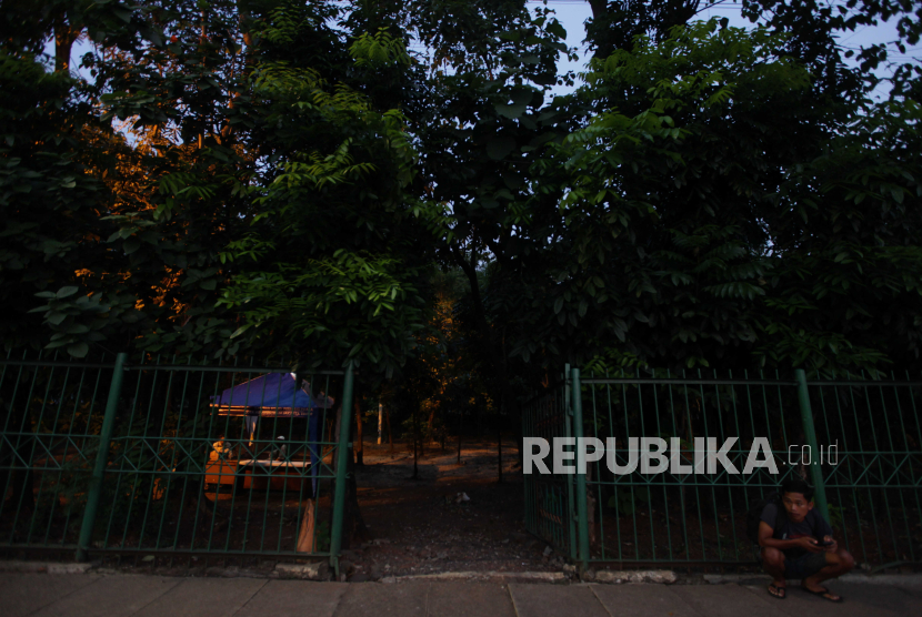 Warga duduk di depan pagar Hutan Kota Cawang, Makasar, Jakarta Timur, Jumat (28/7/2023), yang sebelumnya dijadikan tempat kumpul komunitas LGBT.
