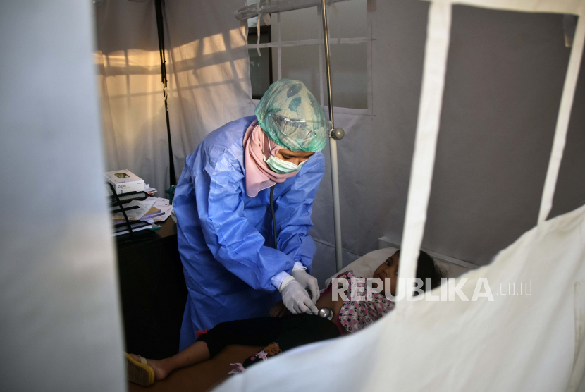 Seorang petugas medis memeriksa pasien pasien Covid-19 (ilustrasi)