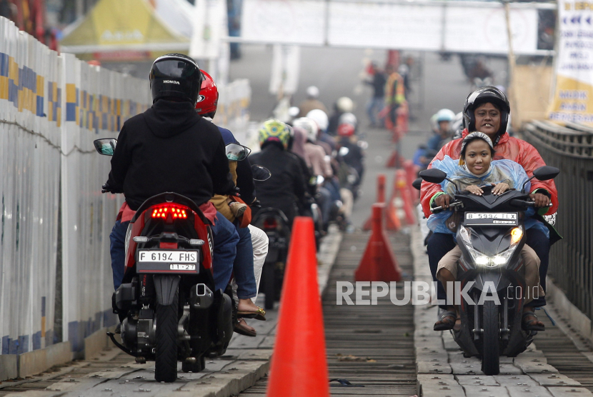Sejumlah pemudik motor melintasi jembatan darurat di jalan raya utama Bogor-Sukabumi, Cikreteg, Kabupaten Bogor, pascalongsor..