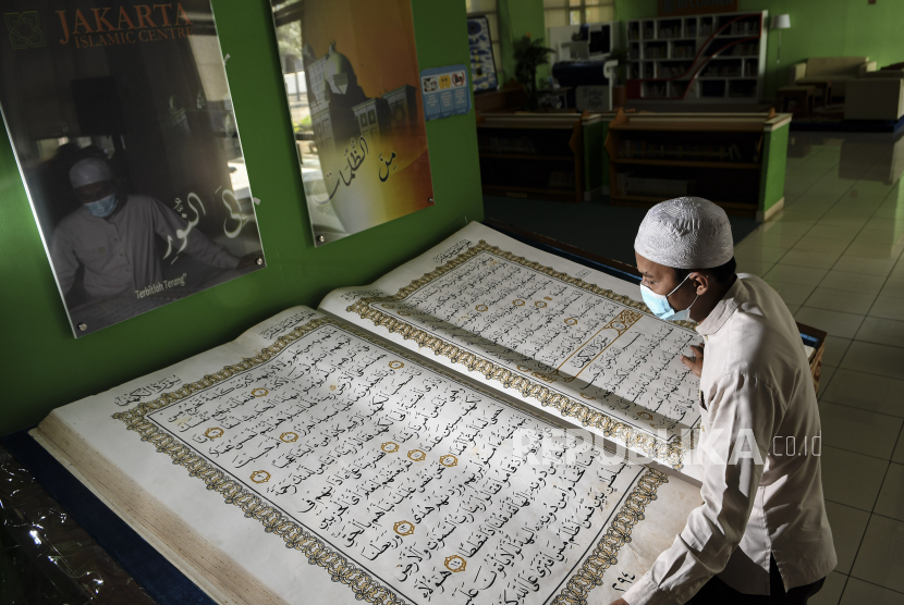 Petugas merawat Al Quran raksasa di Perpustakaan Jakarta Islamic Centre (JIC), Jakarta Utara
