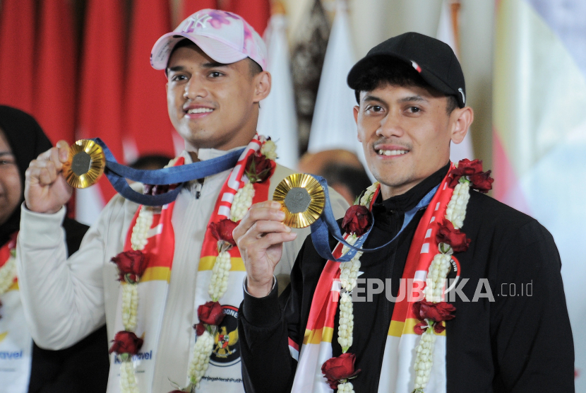 Atlet panjat tebing Indonesia Veddriq Leonardo bersama atlet angkat besi Rizki Juniansyah berpose menunjukan medali emas Olimpiade Paris 2024 saat tiba di Bandara Soekarno Hatta, Tangerang, Banten, Selasa (13/8/2024). Rombongan atlet Indonesia bersama peraih medali emas Veddriq Leonardo dan Rizki Juniansyah tiba di bandara sekitar pukul 22.43 WIB disambut tepuk tangan dari keluarga dan kerabat. Tim Indonesia berhasil meraih dua medali emas dari cabang olahraga panjat tebing putra Veddriq Leonardo dan angkat besi putra Rizki Juniansyah serta medali perunggu cabang olahraga bulutangkis tunggal putri Gregoria Mariska Tunjung.