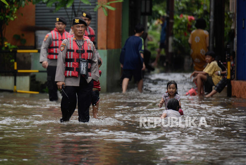 Polisi mengecek pemukiman warga yang terdampak banjir di kawasan Petogogan, Jakarta, Jumat (24/2/2023). Dinas Gukarmat DKI Jakarta menyiagakan petugas di 139 pos untuk mengantisipasi banjir.