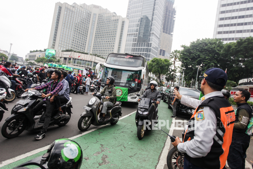 Petugas Dishub mengatur lalu lintas saat massa buruh melakukan aksi di kawasan Bundaran HI, Jakarta, Rabu (1/5/2024).