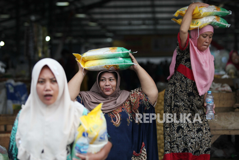 Warga mengangkut beras SPHP yang dibelinya saat pasar murah di Pasar Induk Surabaya Sidotopo, Surabaya, Jawa Timur, Rabu (21/2/2024).