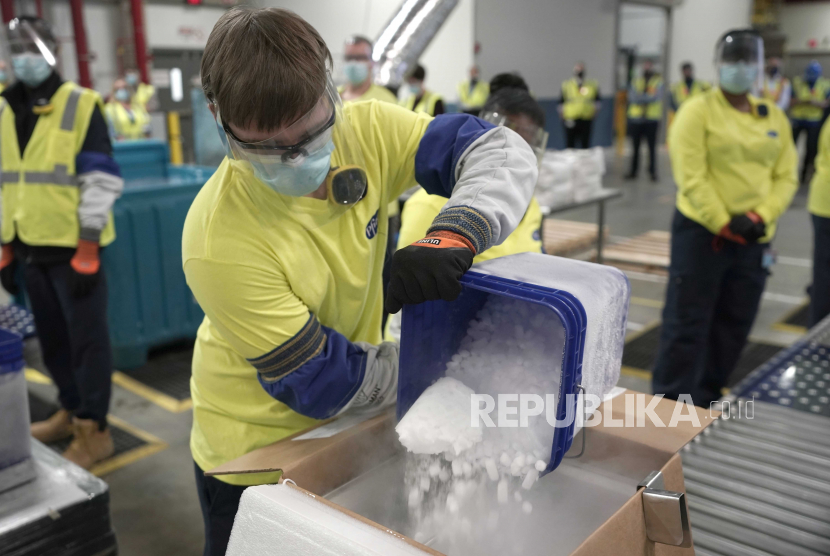  Es kering dituangkan ke dalam kotak berisi vaksin Pfizer-BioNTech COVID-19 yang disiapkan untuk dikirim di pabrik manufaktur Pfizer Global Supply Kalamazoo di Portage, Mich., Minggu, 13 Desember 2020.