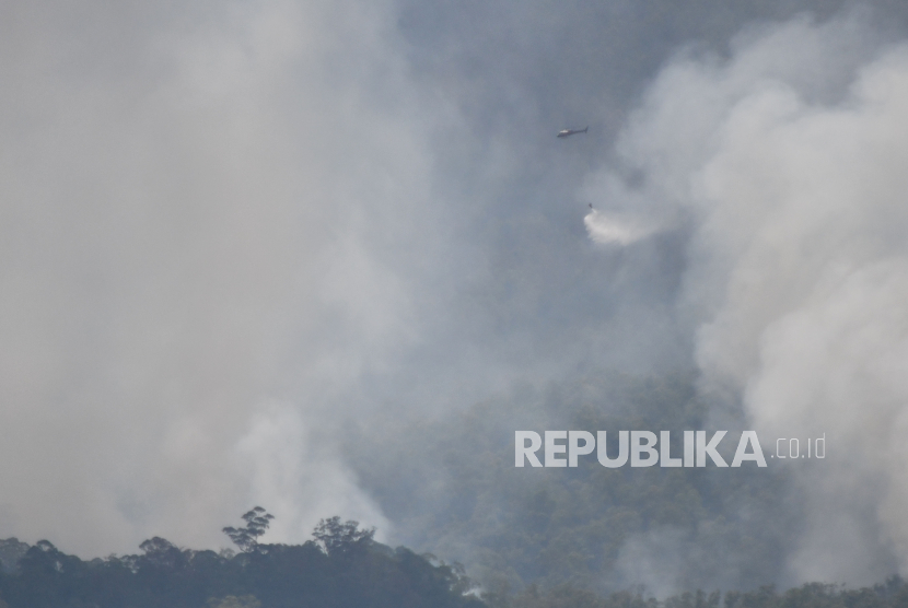 Tim Badan Nasional Penanggulangan Bencana (BNPB) menggunakan helikopter water bombing untuk memadamkan kebakaran di kawasan Gunung Lawu yang terbakar di Ngawi, Jawa Timur, Rabu (4/10/2023). BNPB mengoperasikan helikopter untuk melakukan pemadaman kebakaran dengan metode water bombing mulai Selasa (4/10) di Gunung Lawu yang terbakar sejak sejak Jumat (29/9/2023). 