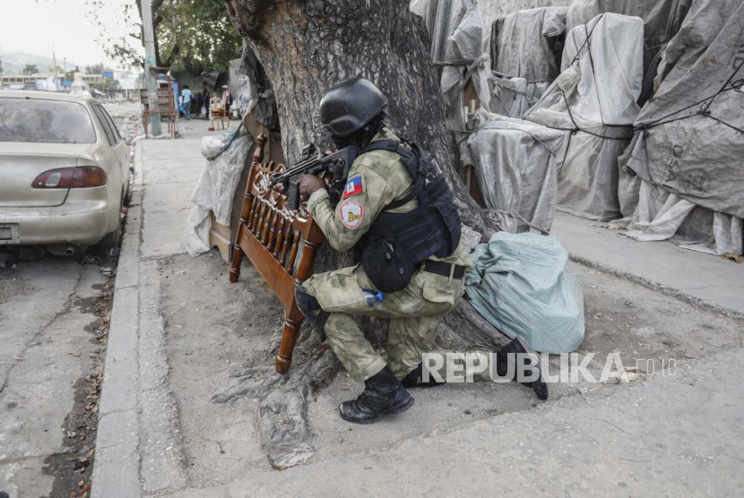 Polisi berlindung selama operasi anti-geng di lingkungan Portail di Port-au-Prince, Haiti, Kamis, (29/2/2024).