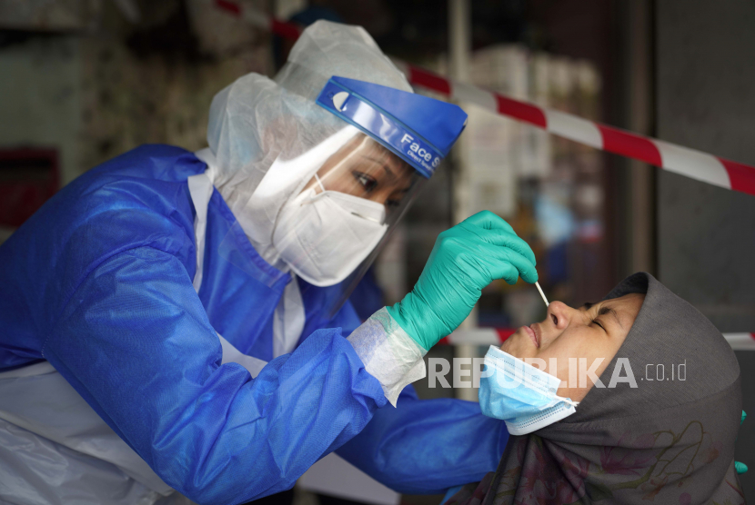  Seorang dokter klinik mengumpulkan sampel untuk pengujian virus corona dari seorang pria di Puchong, di pinggiran Kuala Lumpur, Malaysia, Selasa, 6 Oktober 2020. 