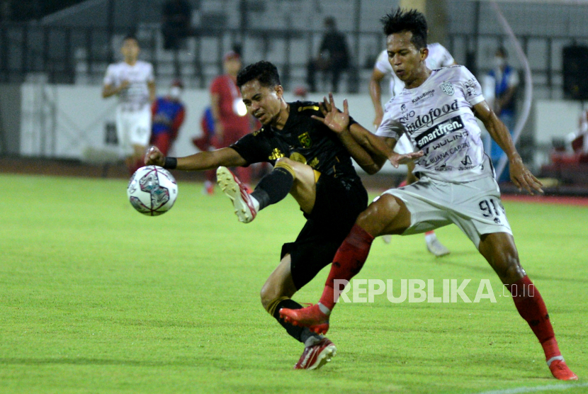 Pesepak bola Bali United M. Rahmat (kanan) berebut bola dengan pesepak bola Persebaya Surabaya Reva Adi Utama (kiri) saat pertandingan Liga 1 di Stadion I Gusti Ngurah Rai, Denpasar, Bali, Rabu (5/1/2022). Persebaya menang 3-1 atas Bali United. 