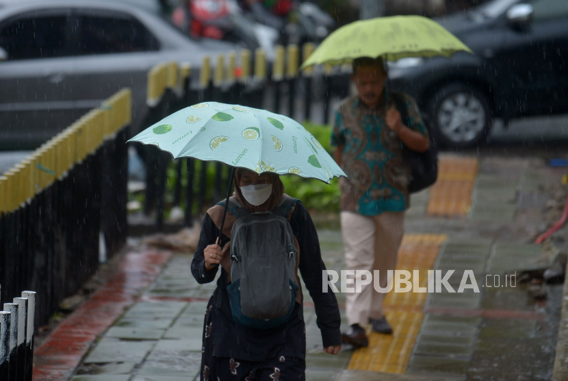 Warga dengan mengunakan payung menerjang hujan di kawasan Jalan  Gatot Subroto, Jakarta (ilustrasi) 