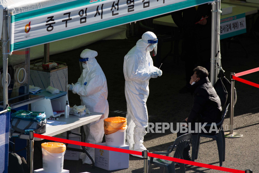 7 Negara Ini Terapkan Aturan Bebas Masker. Seorang pekerja medis (2-L) menyeka warga untuk tes COVID-19 di sebuah klinik darurat di Seoul, Korea Selatan, 15 Desember 2020.