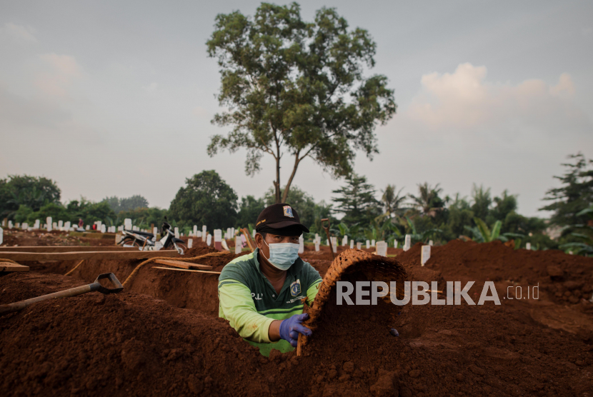 Petugas menggali liang kubur di TPU Pondok Ranggon, Jakarta Timur.