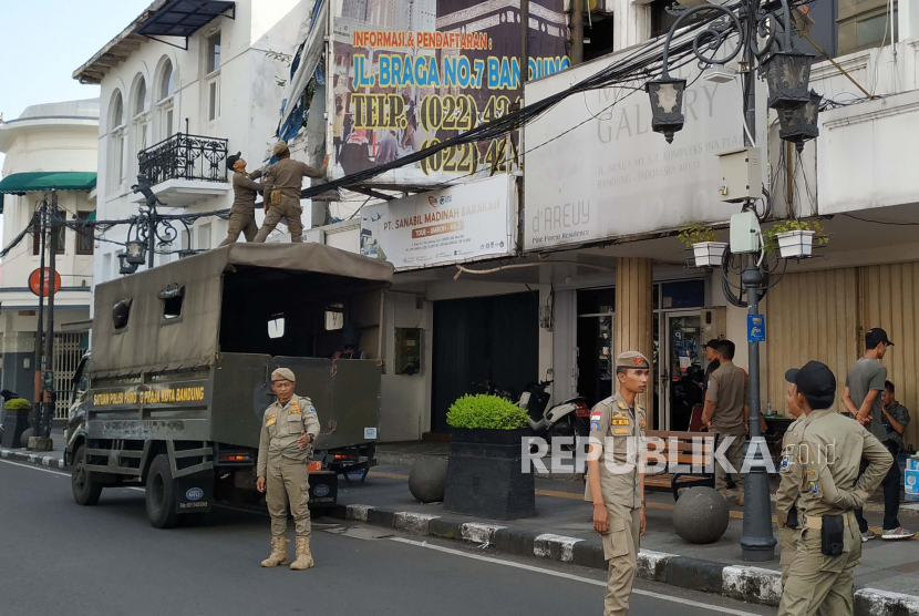 Para petugas Satpol PP Kota Bandung berjaga di Jalan Braga dan kawasan Alun-alun Kota Bandung. Pemkot Bandung menegaskan PKL dilarang beroperasi di zona merah.