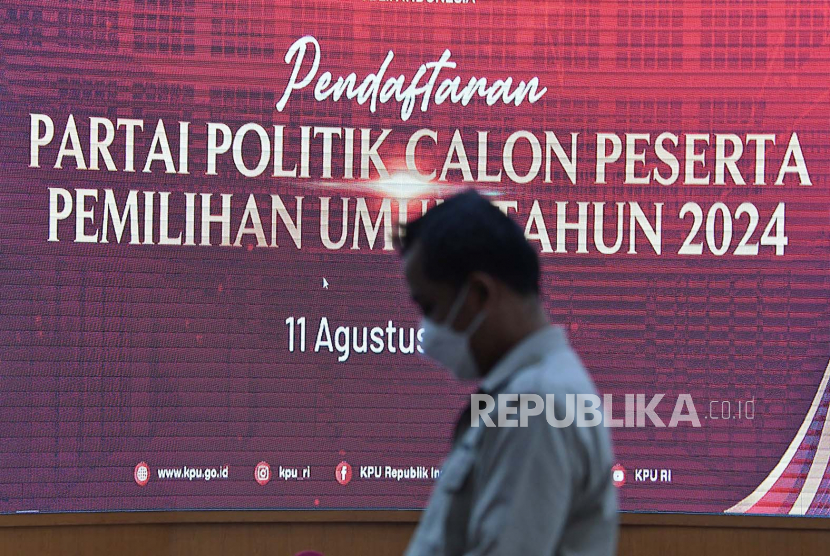 Seorang karyawan melintas layar digital pendaftaran Partai Politik Calon Peserta Pemilu 2024 di Kantor KPU, Jakarta.