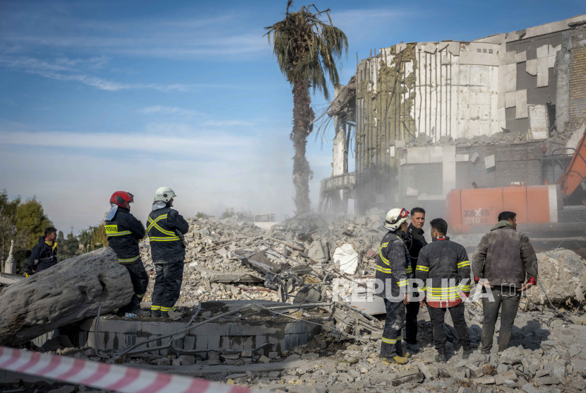   Layanan darurat membersihkan puing-puing rumah Peshraw Dizayi yang terkena serangan rudal Iran di Irbil, Irak, Selasa, (16/1/2024).