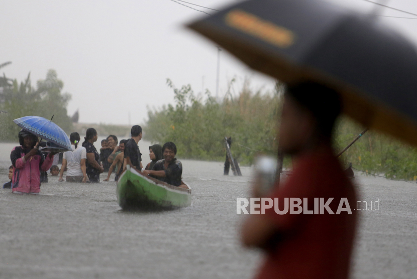 Sejumlah warga melintasi genangan air untuk mengungsi ke tempat yang lebih tinggi di Desa Hutadaa, Kecamatan Telaga jaya, Kabupaten Gorontalo, Gorontalo, Rabu (10/7/2024). 