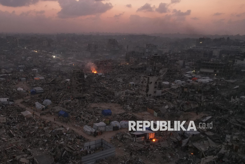 Foto udara yang diambil dengan drone menunjukkan tenda-tenda di antara reruntuhan bangunan yang hancur akibat serangan udara dan darat Israel di Jabaliya, Jalur Gaza, Ahad (16/2/2025).