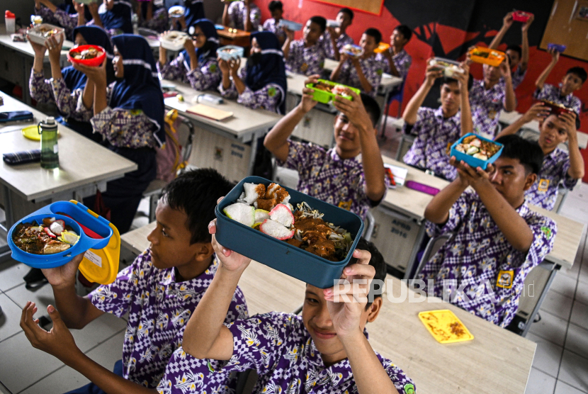Sejumlah siswa menunjukkan makanan gratis saat simulasi program makan siang gratis di SMP Negeri 2 Curug, Kabupaten Tangerang, Banten, Kamis (29/2/2024). 