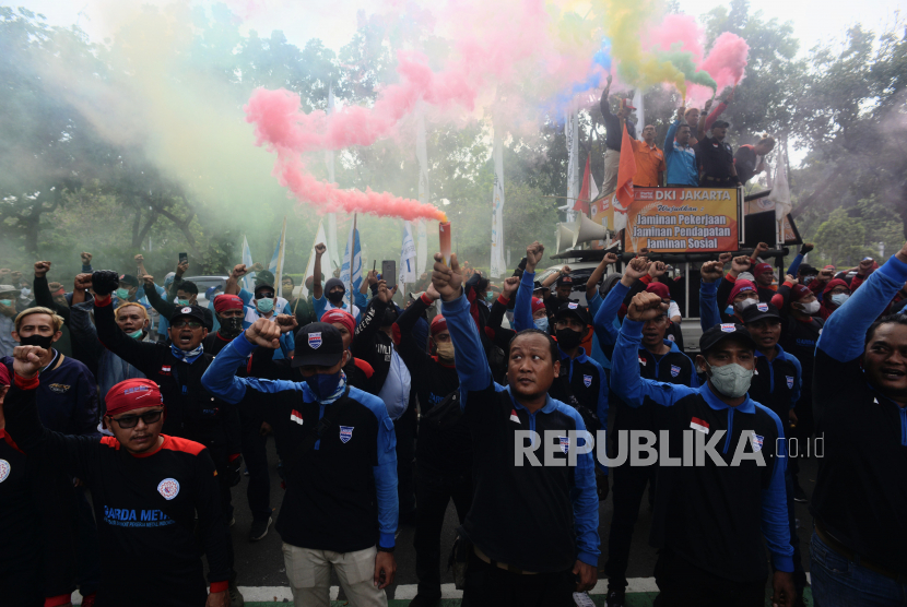 Sejumlah buruh menyalakan suar saat melaksanakan aksi menolak putusan PTUN DKI terkait UMP 2022 di depan Balai Kota DKI, Jakarta Pusat, Rabu (20/7/2022).
