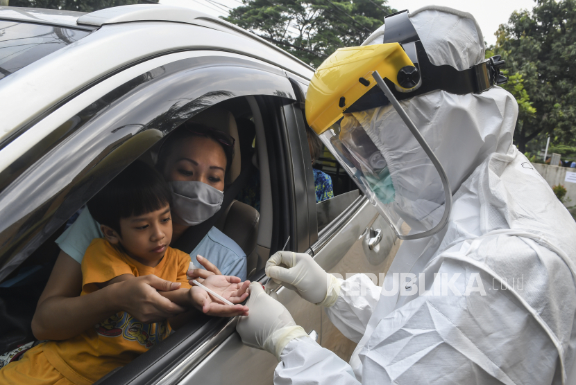 Petugas Dinas Kesehatan Kota Depok melakukan pengecekan kepada pengguna kendaraan saat tes cepat (rapid test) COVID-19 dengan sistem   drive thru di Cimanggis, Depok, Jawa Barat, Ahad (29/3/2020).  