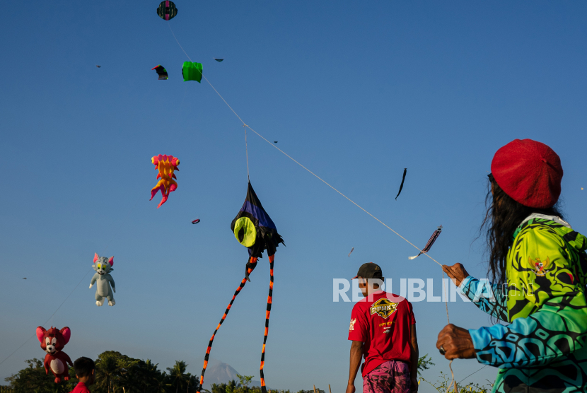 Peserta menerbangkan layang-layang saat Ngaran Kite Festival 2023 bertajuk Akar Tumbuh, Budaya Tangguh di areal persawahan kampung Ngaran, Margokaton, Seyegan, Sleman, DIY, Sabtu (9/9/2023).