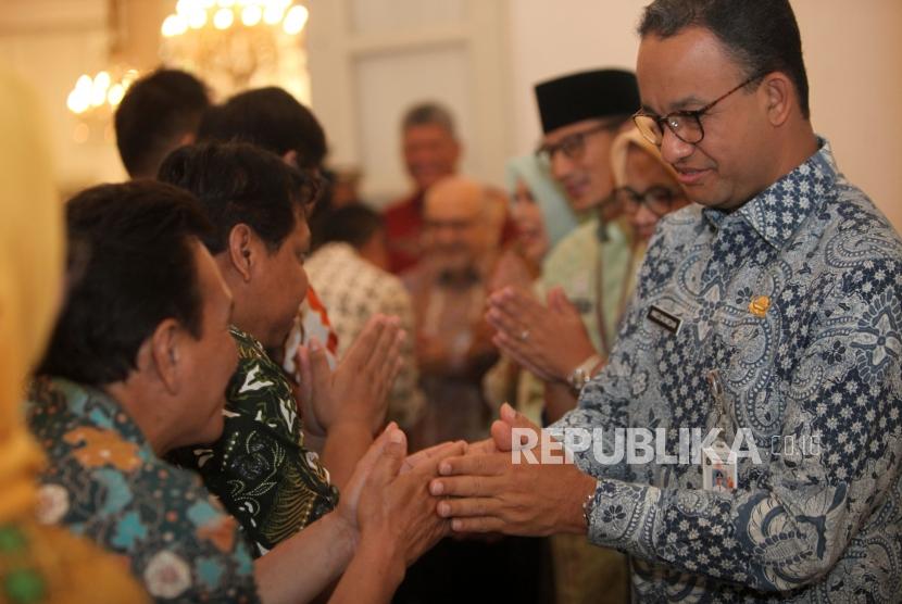 Gubernur DKI Jakarta Anies Baswedan (kanan) didampingi istrinya dan Wakil Gubernur Sandiaga Uno (kiri) bersalaman dengan pegawai Pemprov DKI Jakarta saat halal bihalal, di Balaikota, Jakarta, Kamis (21/6).