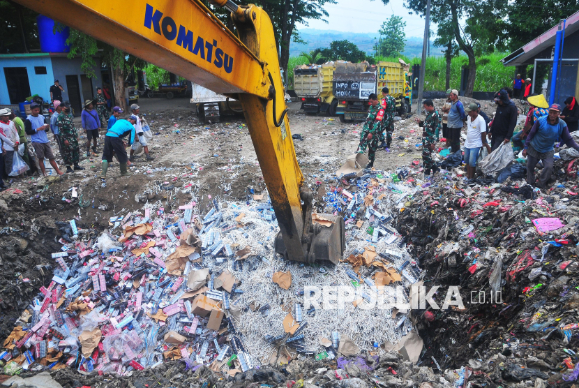 Petugas menggunakan alat berat mengubur rokok ilegal di Tempat Pembuangan Akhir (TPA) Tanjungrejo, Kudus, Jawa Tengah, Kamis (21/11/2024). Kantor Bea Cukai Kudus selama 1 Januari-20 November 2024 memusnahkan sebanyak 20,83 juta batang rokok ilegal hasil dari 150 penindakan dengan perkiraan nilai barang sebesar Rp28,70 miliar dengan potensi kerugian negara sebesar Rp19,96 miliar. 