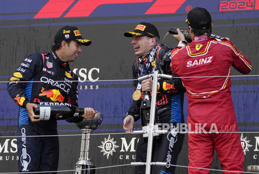 Red Bull driver Max Verstappen, center, sprays champagne Second placed Red Bull driver Sergio Perez, left, of Mexico, and third place Ferrari driver Carlos Sainz of Spain as on the podium after the Japanese Formula One Grand Prix at the Suzuka Circuit in Suzuka, central Japan, Sunday, April 7, 2024. 