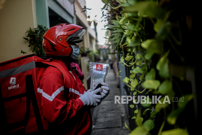 Kurir mengirim paket obat Covid-19 ke rumah pasien yang menjalani isolasi mandiri di kawasan Johar Baru, Jakarta. Data LaporCovid-19 menyebut setidaknya 1.200 pasien isolasi mandiri (isoman) di Jakarta meninggal dunia.