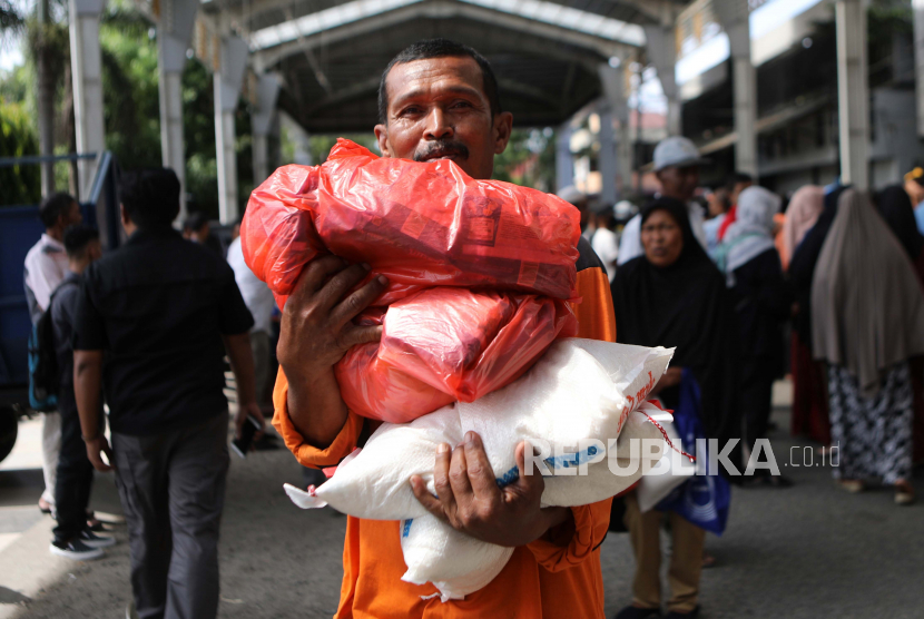  Seorang pria memegang paket sembako di Banda Aceh,  Senin (3/4 2023). Pemerintah menyebut lebih dari setengah anggaran negara dinikmati warga miskin.