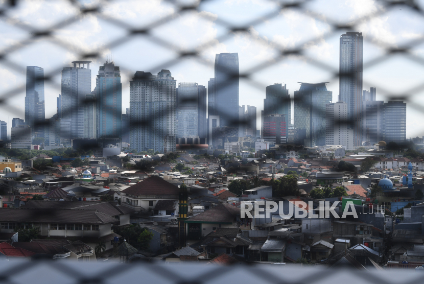 Deretan rumah di kawasan padat penduduk dengan latar belakang gedung bertingkat di Jakarta, Senin (4/7/2022). Pemprov DKI Jakarta membebaskan Pajak Bumi dan Bangunan Perdesaan dan Perkotaan (PBB-P2) untuk rumah warga Ibu Kota dengan Nilai Jual Objek Pajak (NJOP) di bawah Rp2 Miliar. 