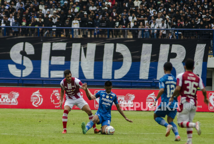 Pesepak bola Persib Bandung Kakang Rudianto (kedua kiri) berebut bola dengan pesepak bola Persis Solo Dvid Gonzalez Gomes (kiri) dalam pertandingan lanjutan BRI Liga 1 di Stadion Gelora Bandung Lautan Api, Bandung, Jawa Barat, Ahad (4/2/2024). Pertandingan tersebut berakhir imbang dengan skor akhir 2-2. 