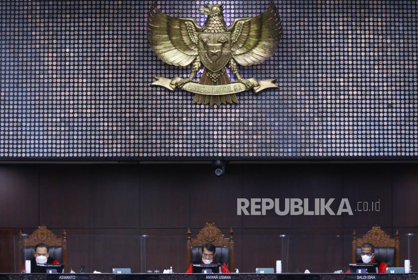 Ketua Majelis Hakim Konstitusi (MK) Anwar Usman (tengah) didampingi Hakim Konstitusi Aswanto (kiri) dan Saldi Isra (kanan) memimpin sidang putusan gugatan Undang-Undang Nomor 11 Tahun 2020 tentang Cipta Kerja yang diajukan kelompok buruh di Mahkamah Konstitusi, Jakarta, Kamis (25/11/2021). Mahkamah Konstitusi memutuskan menolak gugatan tersebut, namun demikian UU Cipta Kerja harus diperbaiki hingga dua tahun ke depan. 